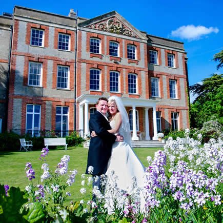 Bride and groom with wildflowers at their wedding in front of Ardington House - Mark Sisley Photography