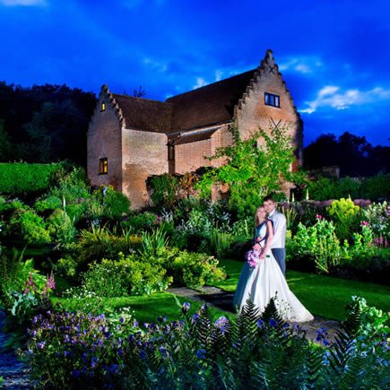 Bride and groom at twilight in front of Chenies Manor - Mark Sisley Photography