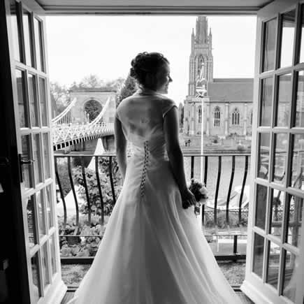 Black and white bride looking through window at Compleat Angler Marlow Bucks - Mark Sisley Photography