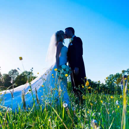 Bride and groom in wildflowers - Mark Sisley Photography