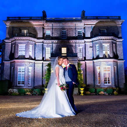 Dramatically lit image of bride and groom at twilight in front of Hedsor House Buckinghamshire - Mark Sisley Photography
