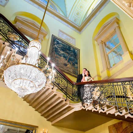 Bride and groom on staircase at Stoke Park Buckinghamshire - Mark Sisley Photography