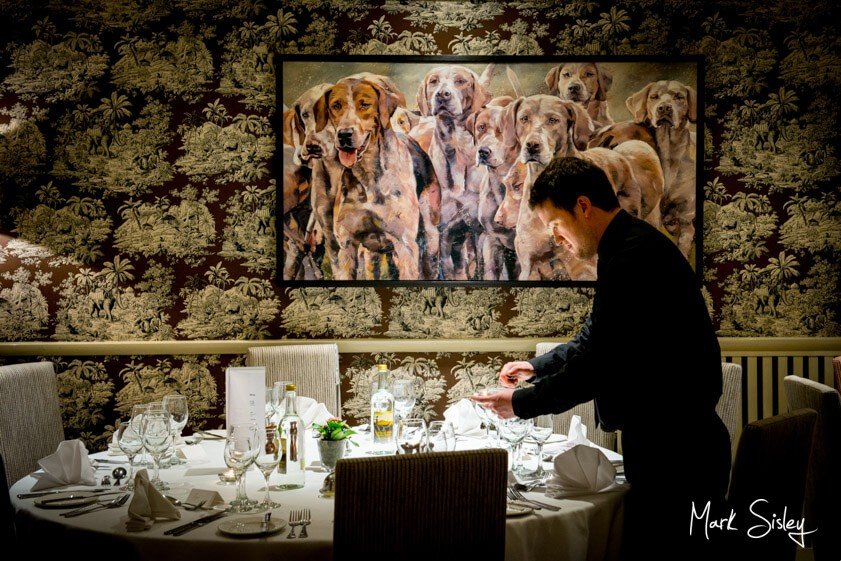 waiter lighting candles on table at Bay Tree Hotel Burford - Mark Sisley Photography