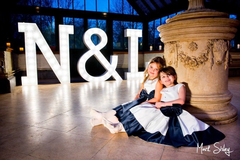 Young bridesmaids in front of giant letters - wedding at The Dairy Waddesdon Manor - Mark Sisley Photography