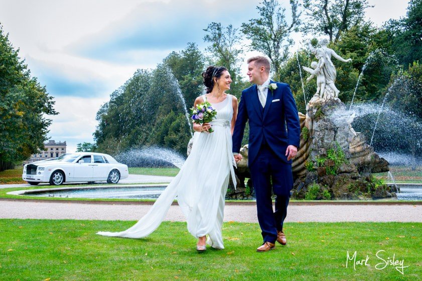 Bride and groom walking on the lawn - wedding at Cliveden House - Mark Sisley Photography