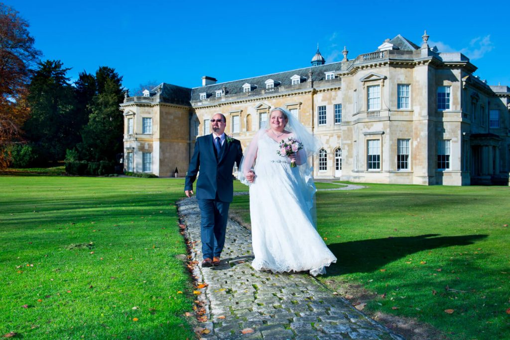 Hartwell House autumn wedding of the newlyweds walking along the cobbled footpath