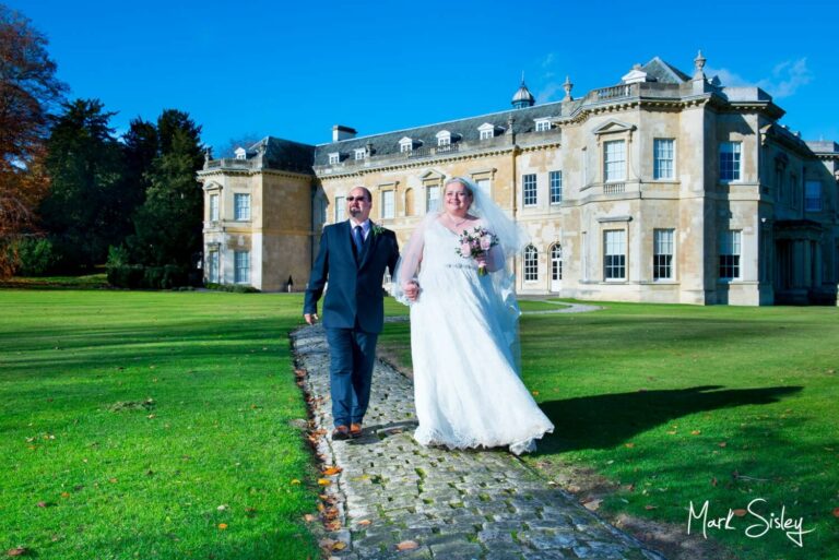 Hartwell House autumn wedding of the newlyweds walking along the cobbled footpath