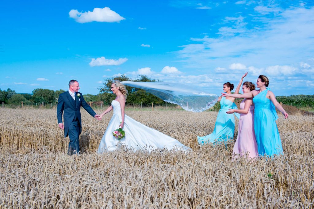 Notley Tythe Barn wedding photography - bride and groom and bridesmaids in a wheat field