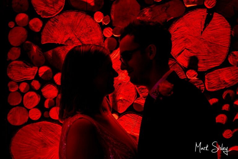 Dramatic indoor after dark silhouette shot captured of the newlyweds at their Manor House Hotel wedding in Moreton-in-Marsh