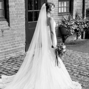 Black and white full length portrait of bride at The Dairy Waddesdon wedding