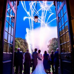 Classic wedding photography Buckinghamshire of a fireworks display captured through a arched feature doorway