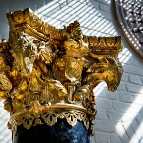 Gold and black column detail with striking sunlight at The Dairy Waddesdon Manor