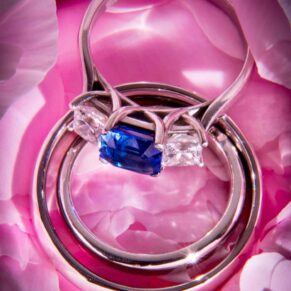 dramatically lit close-up image of pink rose with wedding rings by Mark Sisley Photography