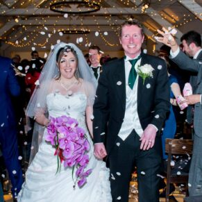 Bride and groom in confetti aisle at Stoke Place wedding