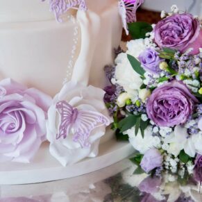 Detail of wedding cake with purple iced butterflies at Taplow House Hotel wedding