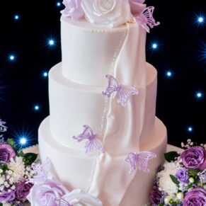 Detail of wedding cake with purple iced butterflies at Taplow House Hotel wedding