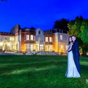 Photography of bride and groom at twilight on the grass in front of Taplow House Hotel on their wedding day