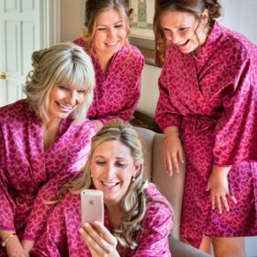 Bride and bridesmaids getting ready in pink dressing gowns for a wedding at Taplow House Hotel