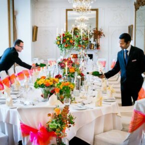 Staff preparing autumnal wedding breakfast place setting at Taplow House Hotel wedding