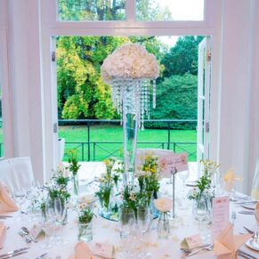 Wedding breakfast head table in bay window for a wedding at Taplow House Hotel with meadow flowers in vases