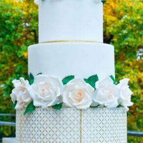 Tall white wedding cake with white roses for a wedding at Taplow House Hotel
