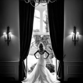 Black and white silhouette image of bride at window at Taplow House Hotel wedding