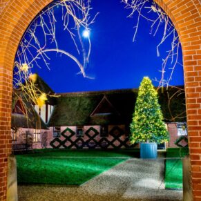 Christmas tree through archway at The Dairy Waddesdon Manor winter wedding