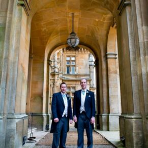 Groom and usher in archway at Waddesdon Manor winter wedding