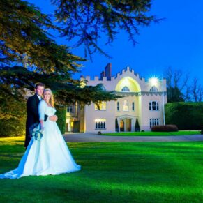 Twilight image of bride and groom on lawn at Hampden House winter wedding