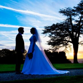 Dramatic silhouette of bride and groom at sunset at Hedsor House winter wedding