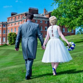 Brocket Hall wedding photographs of the bride and groom walking towards the house