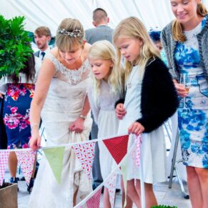 Buckinghamshire marquee wedding photography of the bride showing the young guests the water feature