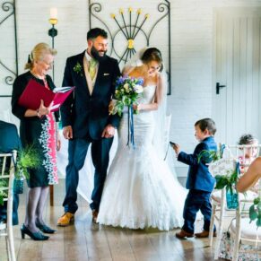Five Arrows Hotel Waddesdon wedding photography of the pageboy asking the bride how to work his camera