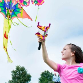 Fun Buckinghamshire outdoor family portraits - young girl flying her kite in an Amersham hilltop location