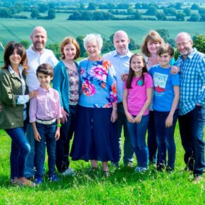 Fun Buckinghamshire outdoor family portraits - a group pose in a hilltop meadow location near Beaconsfield