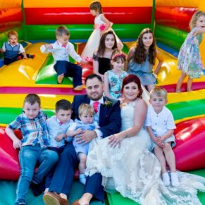 Missenden Abbey wedding celebration - the newlyweds share the bouncy castle with the young wedding guests