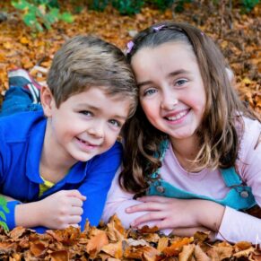 Amersham and Beaconsfield autumn portraits of a young brother and sister laying in the leaves