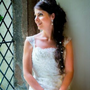 Clearwell Castle bridal wedding pose in the leaded window