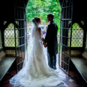 Clearwell Castle - St. Peter's Church wedding photography of the newlyweds posing for a silhouette shot in the doorway