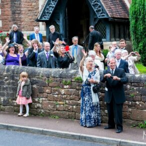 Clearwell Castle - St. Peter's Church wedding photography of the guests outside the building