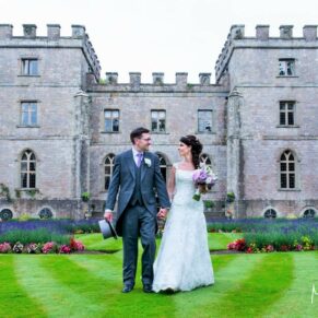 Clearwell Castle wedding image of the newlyweds strolling in front of the castle