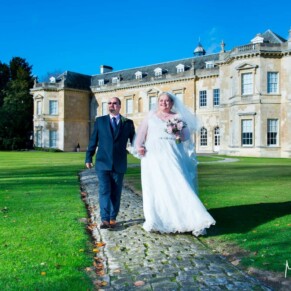 Hartwell House autumn wedding of the newlyweds walking along the cobbled footpath