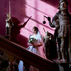 Hartwell House wedding photography of the bride on the staircase with sunlight streaming through the windows