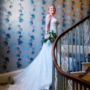 Bridal window lit photography of the bride on the staircase at St Michaels Manor wedding venue in St.Albans