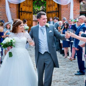 The newlyweds walk through the reception aisle at their Dairy Waddesdon Manor wedding