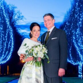 Danesfield House winter wedding photography of the newlyweds with the illuminated tree aisle at the entrance