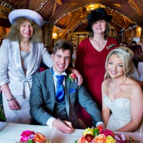 Signing the register at Notley Tythe Barn wedding