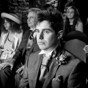 Black and white image of groom at Notley Tythe Barn wedding