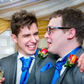 Groom and usher laughing at Notley Tythe Barn wedding