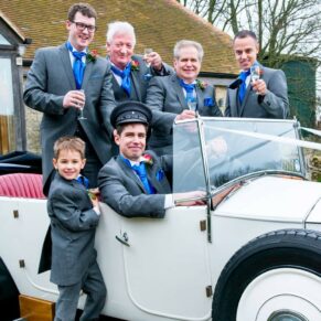 Ushers larking about in vintage car at Notley Tythe Barn wedding